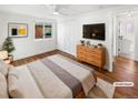 Bright bedroom features a ceiling fan, wood floors, and a walk in closet with an ensuite bathroom at 1479 S Bellaire St, Denver, CO 80222