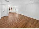 Open-concept room with hardwood floors, bright white walls, and doors leading to the backyard at 1479 S Bellaire St, Denver, CO 80222
