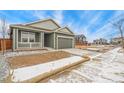 View of the single Gathering home, featuring a front porch and two car garage at 1595 Orchard St, Brighton, CO 80601