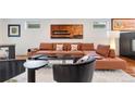 Cozy living room featuring a large sectional sofa, plush rug, modern artwork, and stylish decor at 2334 Lowell Blvd, Denver, CO 80211