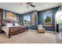 Spacious main bedroom with a wooden bed frame, neutral carpet, and natural light from windows at 2334 Lowell Blvd, Denver, CO 80211
