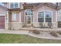 Close-up of the home's entrance, showcasing the covered porch with seating at 8426 W 97Th Pl, Broomfield, CO 80021