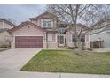 Inviting two-story home featuring a covered porch and manicured front lawn at 8426 W 97Th Pl, Broomfield, CO 80021