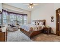 Cozy main bedroom featuring a large window, ceiling fan, and comfortable furniture at 8426 W 97Th Pl, Broomfield, CO 80021