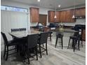 Spacious kitchen featuring wood cabinets, granite countertops, a breakfast bar and a dining area at 4995 S Algonquian Way, Aurora, CO 80016