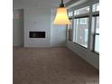 Bright living room with large windows, a fireplace, plush carpet, and modern lighting for a welcoming atmosphere at 4995 S Algonquian Way, Aurora, CO 80016