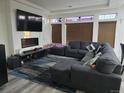 Comfortable living room with a gray sectional sofa, sleek entertainment center and a large television at 4995 S Algonquian Way, Aurora, CO 80016