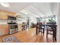 Bright kitchen flowing into a dining and living area featuring a stainless steel oven and light wooden cabinets at 33 N Corona St # 404, Denver, CO 80218