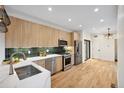 Modern kitchen with stainless steel appliances, white counters, and tiled backsplash at 1745 Lowell Blvd, Denver, CO 80204