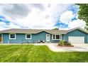 Quaint single story home with well-kept lawn, landscaping, and cozy front patio at 1853 Burton St, Strasburg, CO 80136