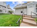 A well-maintained townhome showing the entrance, gray siding, and lush green lawn at 17004 E Tennessee Dr # 103, Aurora, CO 80017