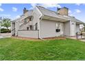 This shows the exterior of a nice, gray townhome with a lush green lawn and rocky beds at 17004 E Tennessee Dr # 103, Aurora, CO 80017