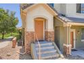 Close-up of a townhouse entrance with stone accents, stairs, and a well-maintained front door at 22560 E Ontario Dr # 204, Aurora, CO 80016