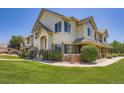 Beautiful townhome showcasing a well-kept lawn, trimmed bushes, and an inviting facade under a sunny sky at 22560 E Ontario Dr # 204, Aurora, CO 80016