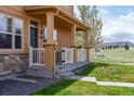 Charming covered front porch with white railing and picturesque view of open green space at 3760 Ute Mountain Trl, Castle Rock, CO 80109