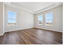Spacious bedroom with hardwood floors, tray ceilings, and plenty of natural light from the large windows at 4949 Hickory Oaks St, Castle Rock, CO 80104