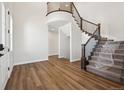 Bright entryway features wood floors, curved staircase with rod iron spindles, and open access to other rooms at 4949 Hickory Oaks St, Castle Rock, CO 80104