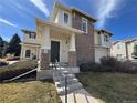 Beautiful home exterior with brick accents, a covered entryway, and manicured landscaping at 13013 Grant Cir # C, Thornton, CO 80241