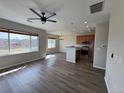 Bright and open living area with hardwood floors, a modern ceiling fan, and large windows showcasing the neighborhood at 13013 Grant Cir # C, Thornton, CO 80241