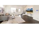 A cozy living room featuring a comfortable couch, modern decor, and dark wood floors with a stylish area rug at 5668 Galena St, Denver, CO 80238