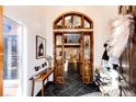 Grand foyer with striking black tile floors, a statement light fixture, and an open view of the home's interior at 11437 Tomichi Dr, Franktown, CO 80116