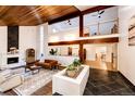 Bright living room with a modern fireplace, a balcony, and views into the adjacent dining area at 11437 Tomichi Dr, Franktown, CO 80116