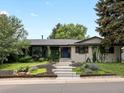 Charming home featuring a manicured lawn, white brick, blue door and lush greenery climbing on the walls at 280 E 11Th Ave, Broomfield, CO 80020