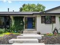 Charming home featuring a manicured lawn, white brick, blue door and lush greenery climbing on the walls at 280 E 11Th Ave, Broomfield, CO 80020