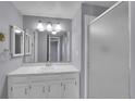 Bathroom with a marble vanity top, framed mirror, and walk-in shower with glass door at 4064 S Atchison Way # 204, Aurora, CO 80014