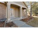 Covered front porch with access to the front door and landscaping at 7944 E Lowry Blvd, Denver, CO 80230