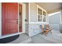 Inviting front porch with a red door, decorative glass, and seating area at 20223 Terrace View Dr, Parker, CO 80134