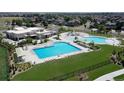 Aerial view of the neighborhood community, showcasing pools, a recreational area, green spaces, and residential homes at 199 Wooten Ave, Brighton, CO 80601