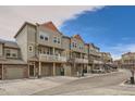 Street view of several townhomes, each with private balconies, garages and neutral exterior colors at 12898 King St, Broomfield, CO 80020