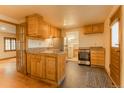 A functional kitchen with stainless appliances, wood cabinets, and an adjoining laundry area at 4850 Forest Hill Rd, Evergreen, CO 80439