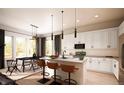 Modern kitchen with white cabinets, quartz countertops, stainless steel appliances, and stylish pendant lighting at 1950 Grayside Cir, Castle Rock, CO 80109