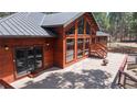 Spacious outdoor deck with wood railings, steps to yard, and large windows at 12655 Greenland Acres Rd, Larkspur, CO 80118