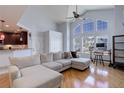 Bright living room with vaulted ceiling, hardwood floors, and expansive windows offering abundant natural light at 6821 W Yale Ave, Lakewood, CO 80227