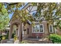 Two-story brick home featuring a covered front porch with sitting area and detailed architectural features at 1250 S Vine St, Denver, CO 80210