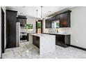 Modern kitchen with stainless steel appliances, marble counters and backsplash, and dark wood cabinets at 3224 W Dakota Ave, Denver, CO 80219