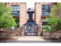 Charming brick building featuring a secure gate and well-maintained landscaping at 930 Acoma St # 106, Denver, CO 80204