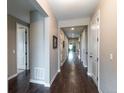 Bright hallway with hardwood floors and neutral walls, leading to various rooms in the house at 565 Pikes View Dr, Erie, CO 80516
