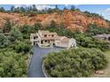 Wonderful home with a terracotta roof, lush surroundings, and a long driveway up to the house providing privacy and curb appeal at 5085 Red Rock Dr, Larkspur, CO 80118