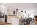 Well-lit kitchen featuring an island with seating, marble counters, stainless steel appliances and modern pendant lights at 2145 High St, Denver, CO 80205