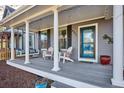 Inviting front porch featuring a porch swing, Adirondack chairs, and stylish decor at 2321 Alton St, Denver, CO 80238