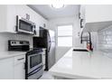 Bright kitchen showcasing stainless steel appliances, quartz countertops, and stylish white cabinetry at 1111 Maxwell Ave # 233, Boulder, CO 80304