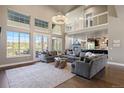 Open concept living room with vaulted ceilings, luxury finishes, and modern furnishings at 1803 Avenida Del Sol, Castle Rock, CO 80104