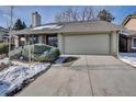 Ranch home exterior featuring a two-car garage, mature landscaping, and an ADT security system at 6417 S Florence Way, Englewood, CO 80111