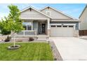 Charming single-Gathering home featuring a landscaped front yard, covered porch, and an attached two-car garage at 965 Peach Leaf Ln, Elizabeth, CO 80107