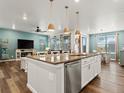 Open-concept kitchen boasts a large island with granite countertops, stainless steel appliances, and pendant lighting at 965 Peach Leaf Ln, Elizabeth, CO 80107