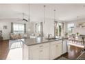 Open-concept kitchen featuring a large island with granite countertops and stainless steel appliances at 3231 Riverwood Way, Castle Rock, CO 80109